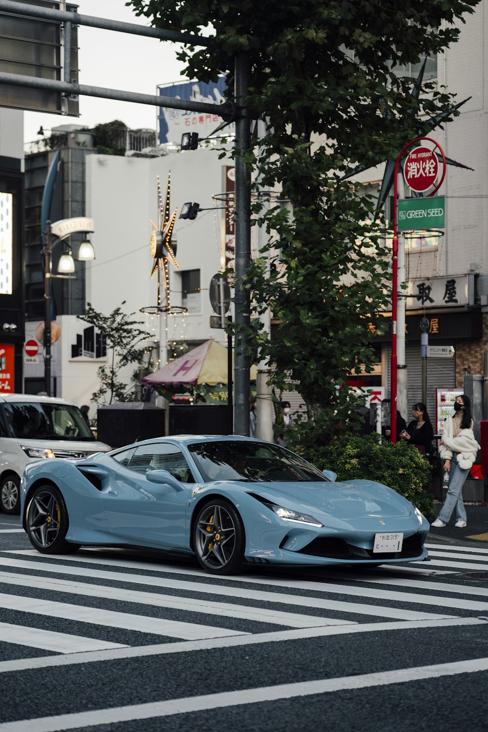 a blue sports car driving down a city street