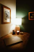 A cozy workspace with handmade mugs and custom t-shirts displayed alongside a softly glowing lamp.