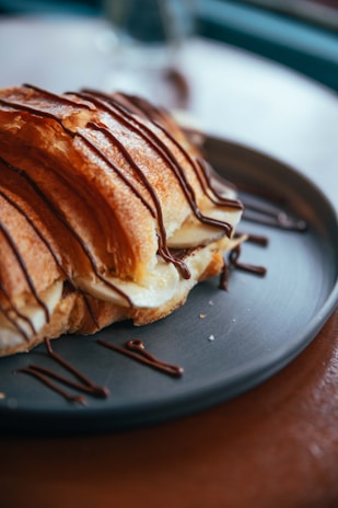 Close-up of a crispy banana cheese pastry with melted cheese oozing out