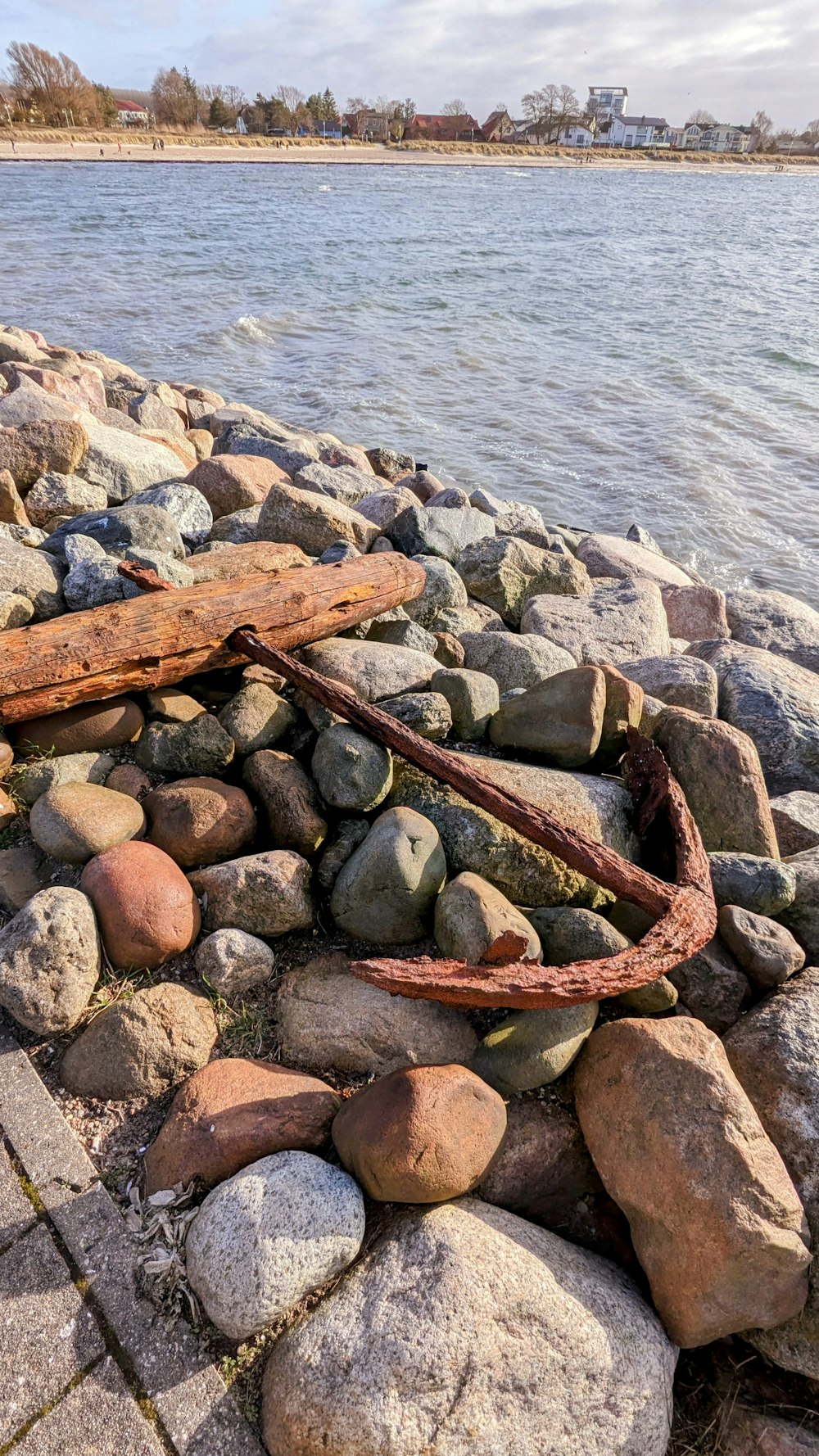 a rusty piece of metal sitting on top of a pile of rocks