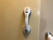 A professional installer fitting grab bars in a bright, accessible bathroom.