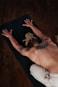 a shirtless man laying on a yoga mat