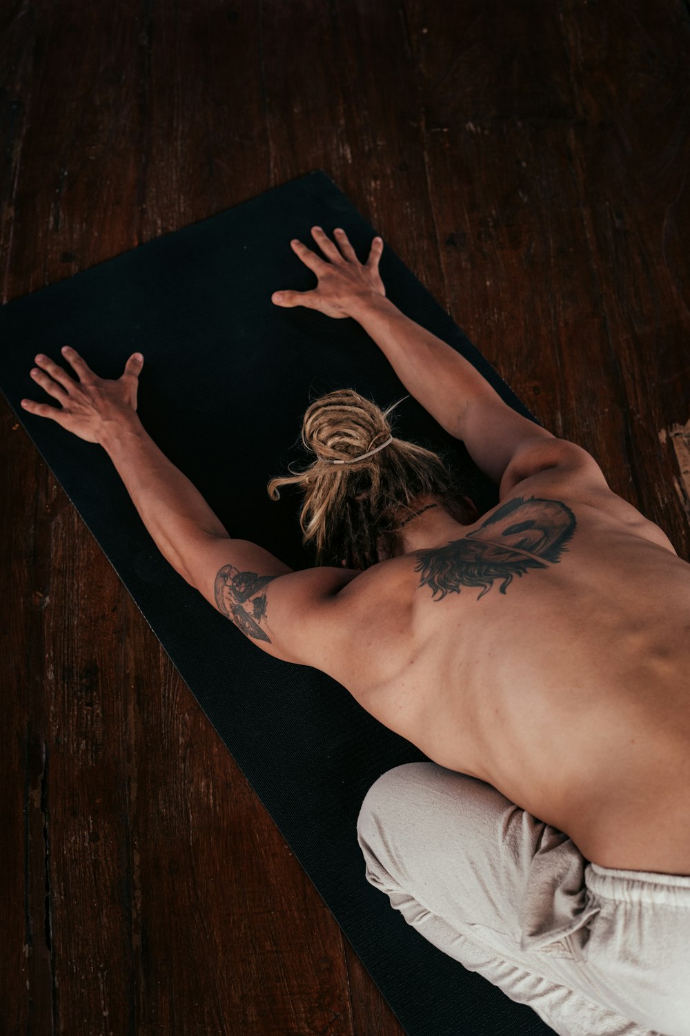 a shirtless man laying on a yoga mat