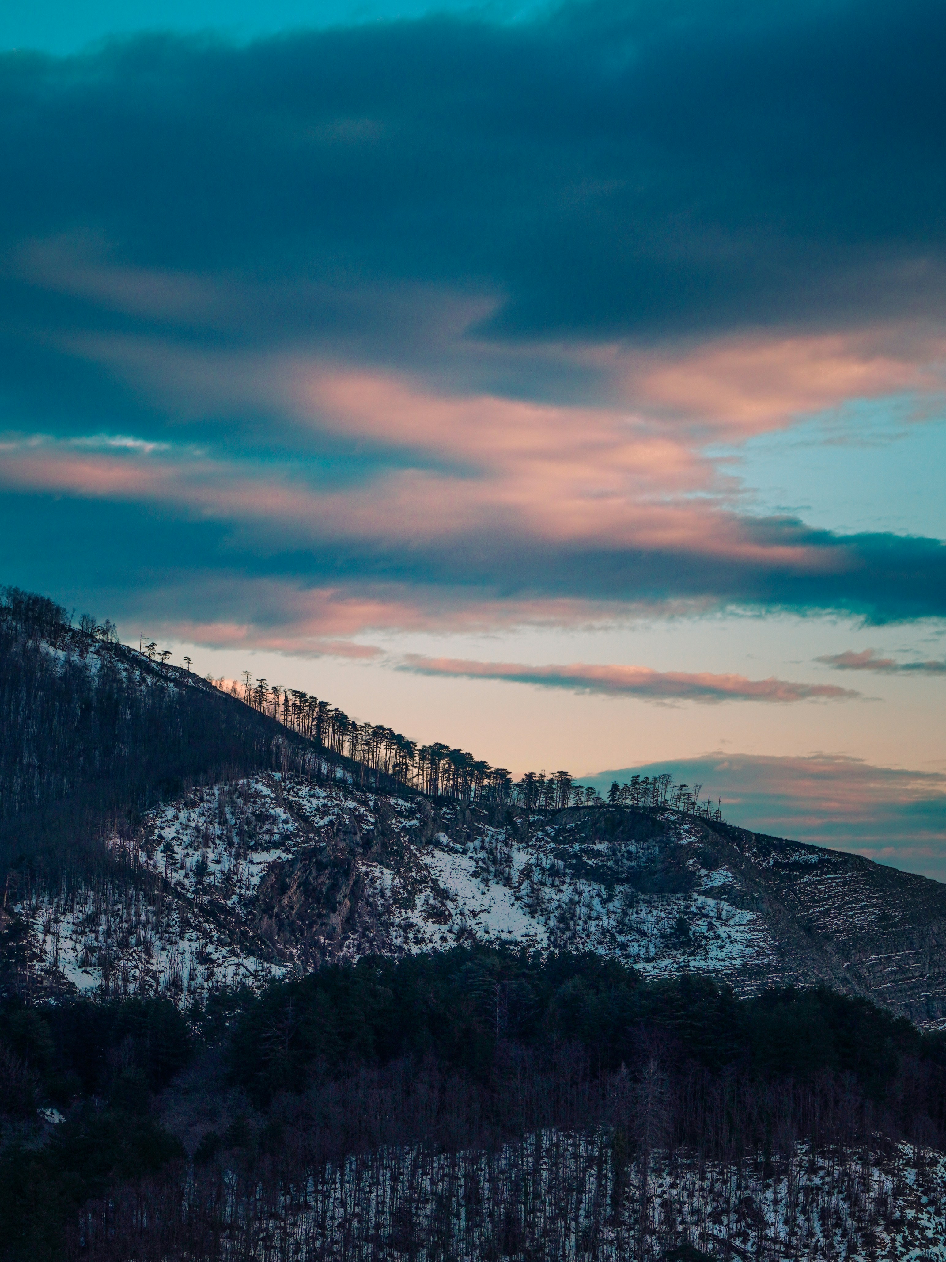 a snow covered mountain under a cloudy sky