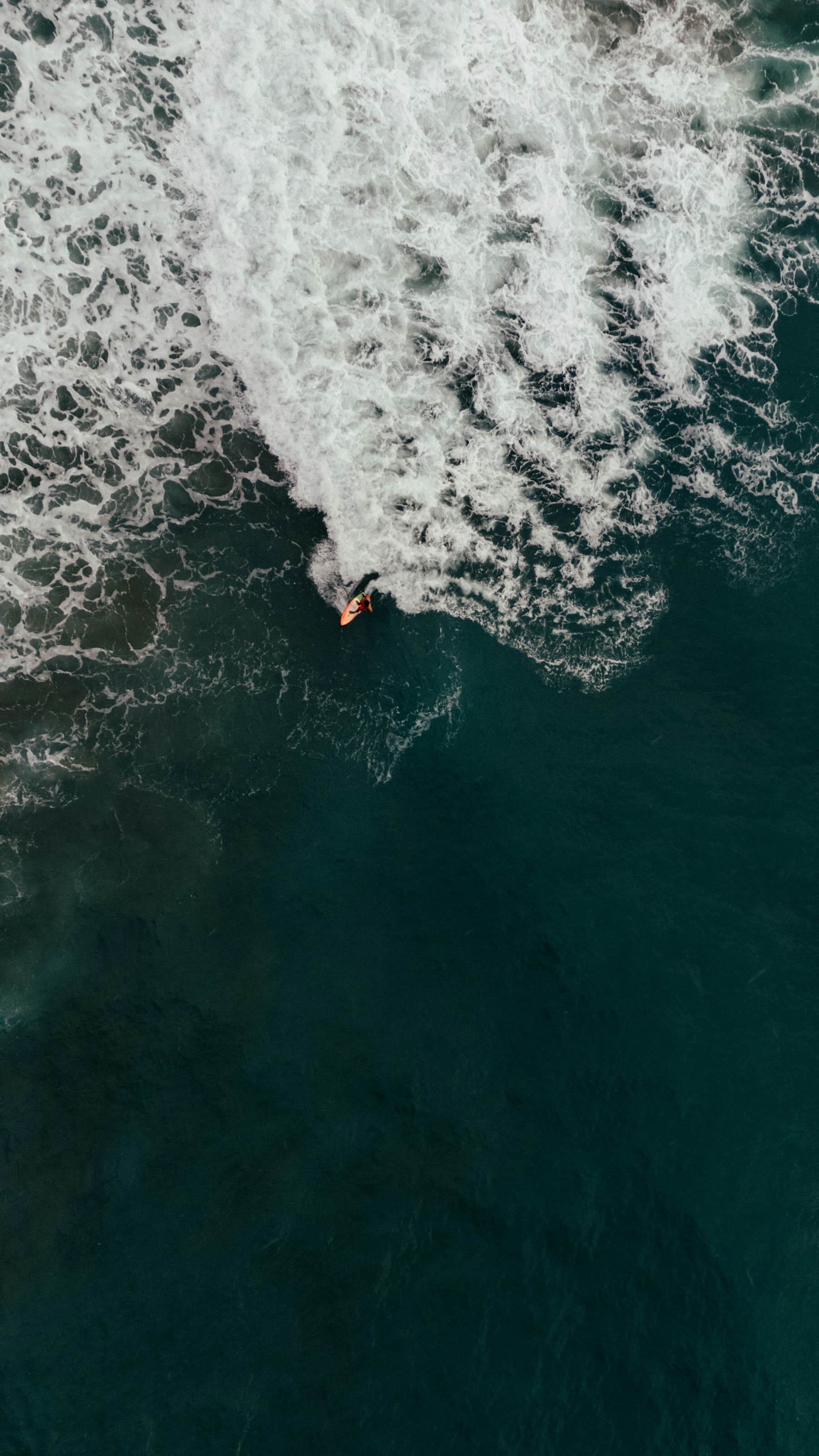 a man riding a surfboard on top of a wave in the ocean