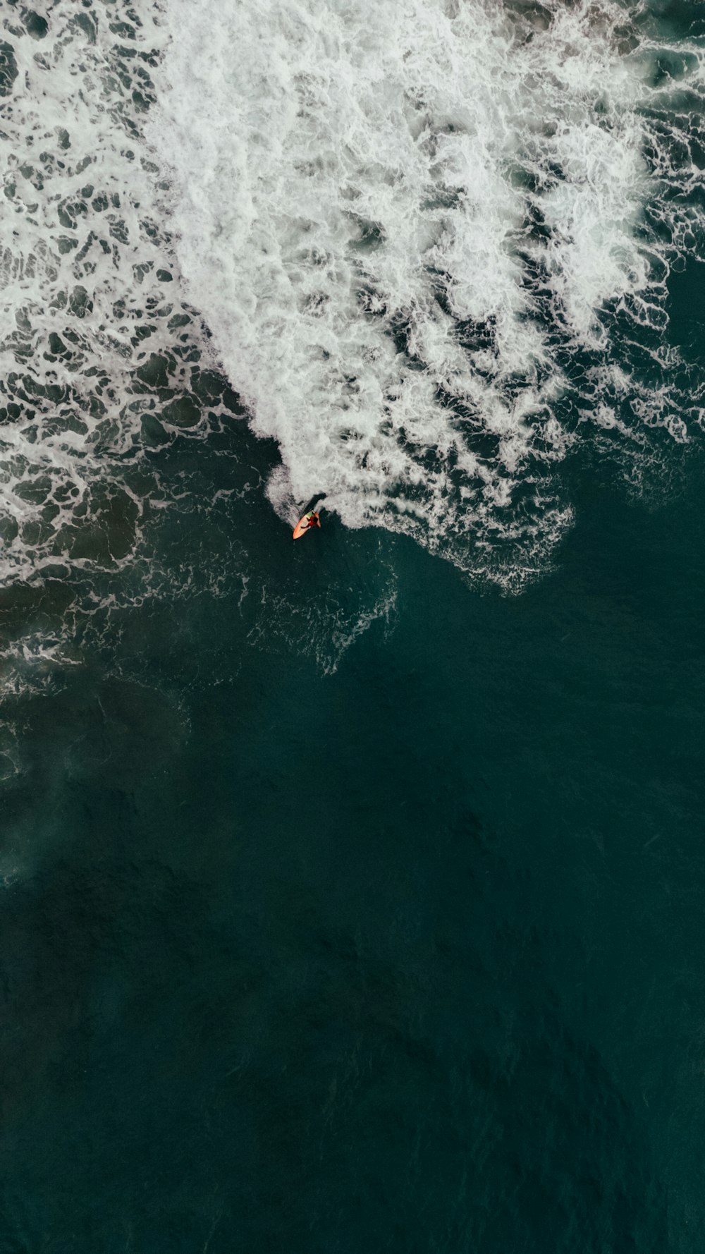 a man riding a surfboard on top of a wave in the ocean