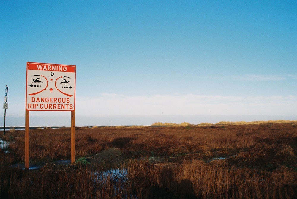 a red and white sign sitting on the side of a road