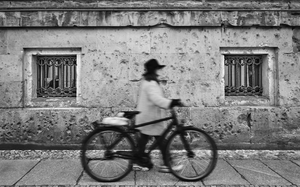 a person riding a bike down a street next to a building