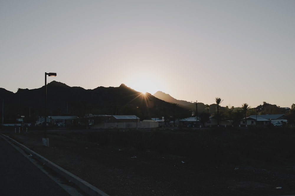 the sun is setting behind a mountain range