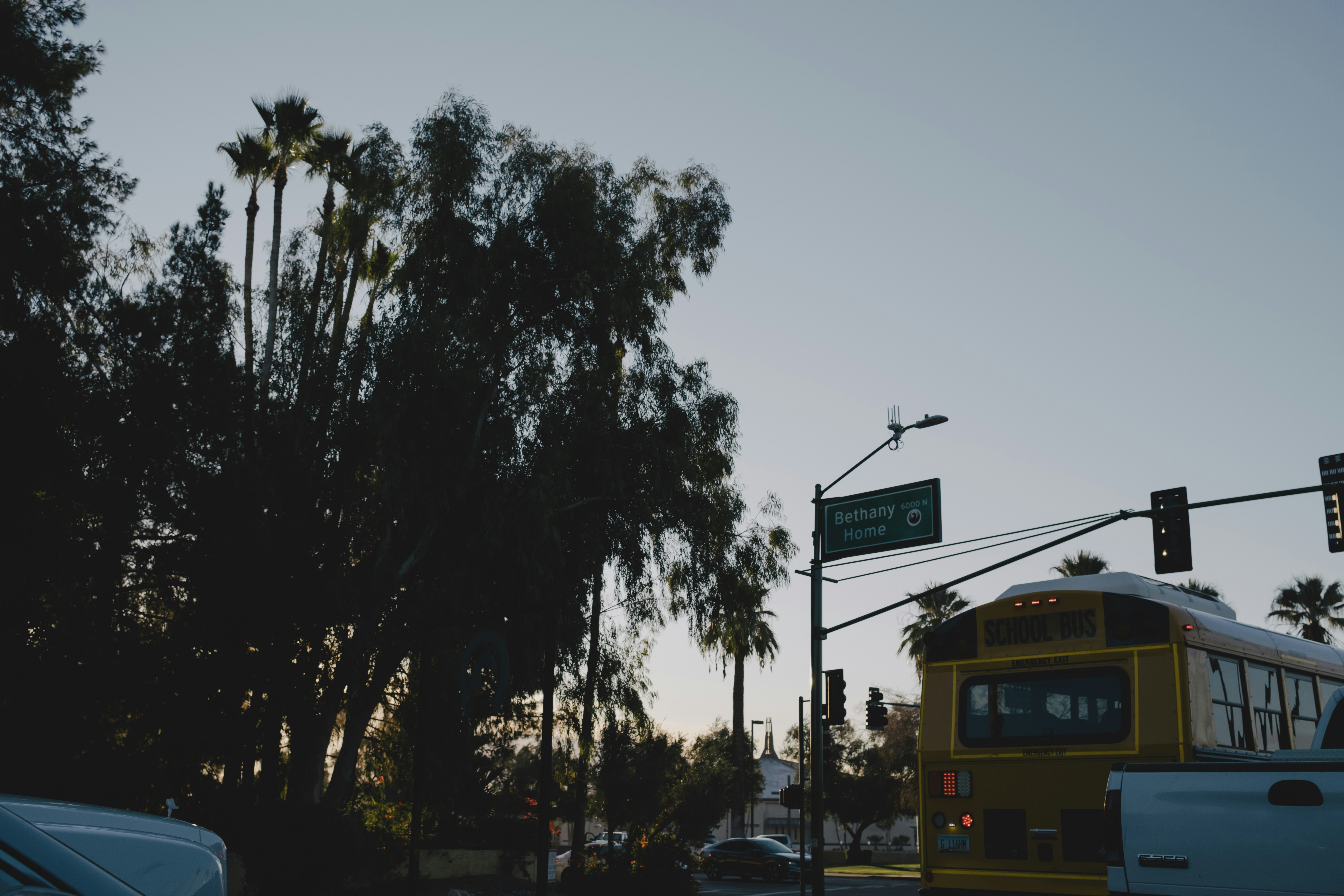 a yellow bus driving down a street next to a traffic light