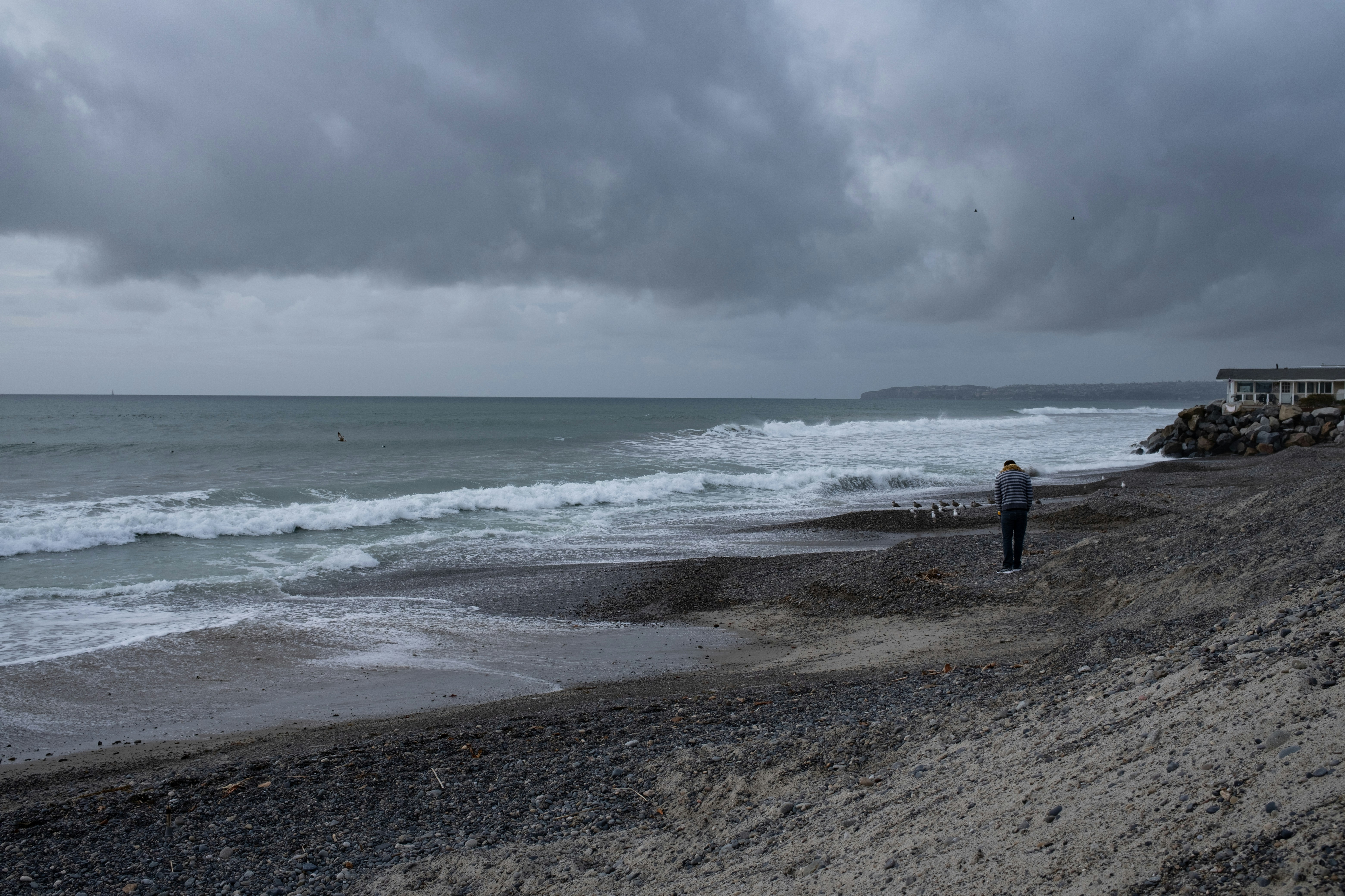 a man standing on a beach next to the ocean