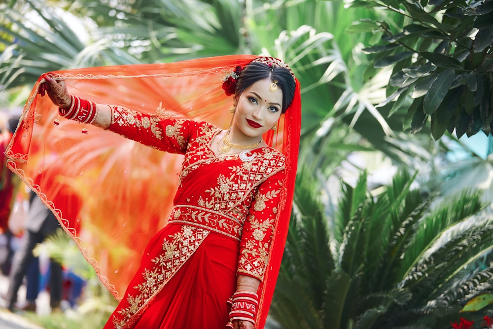 a woman in a red and gold bridal outfit