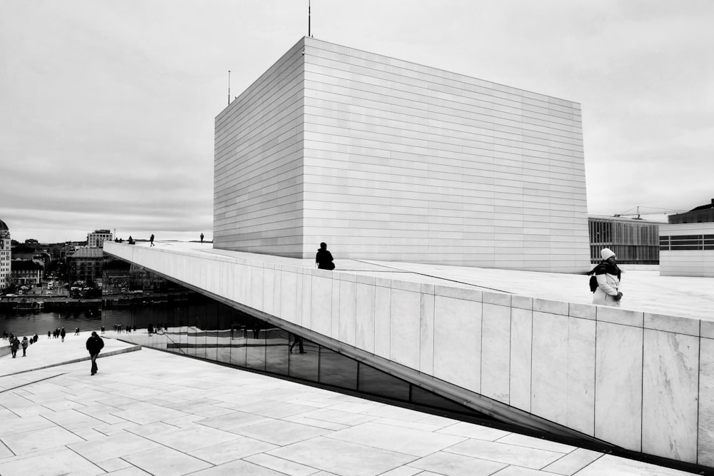 a black and white photo of people walking on a walkway