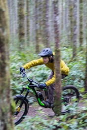 a man riding a mountain bike through a forest