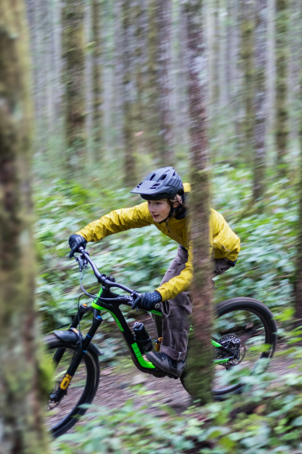 a man riding a mountain bike through a forest