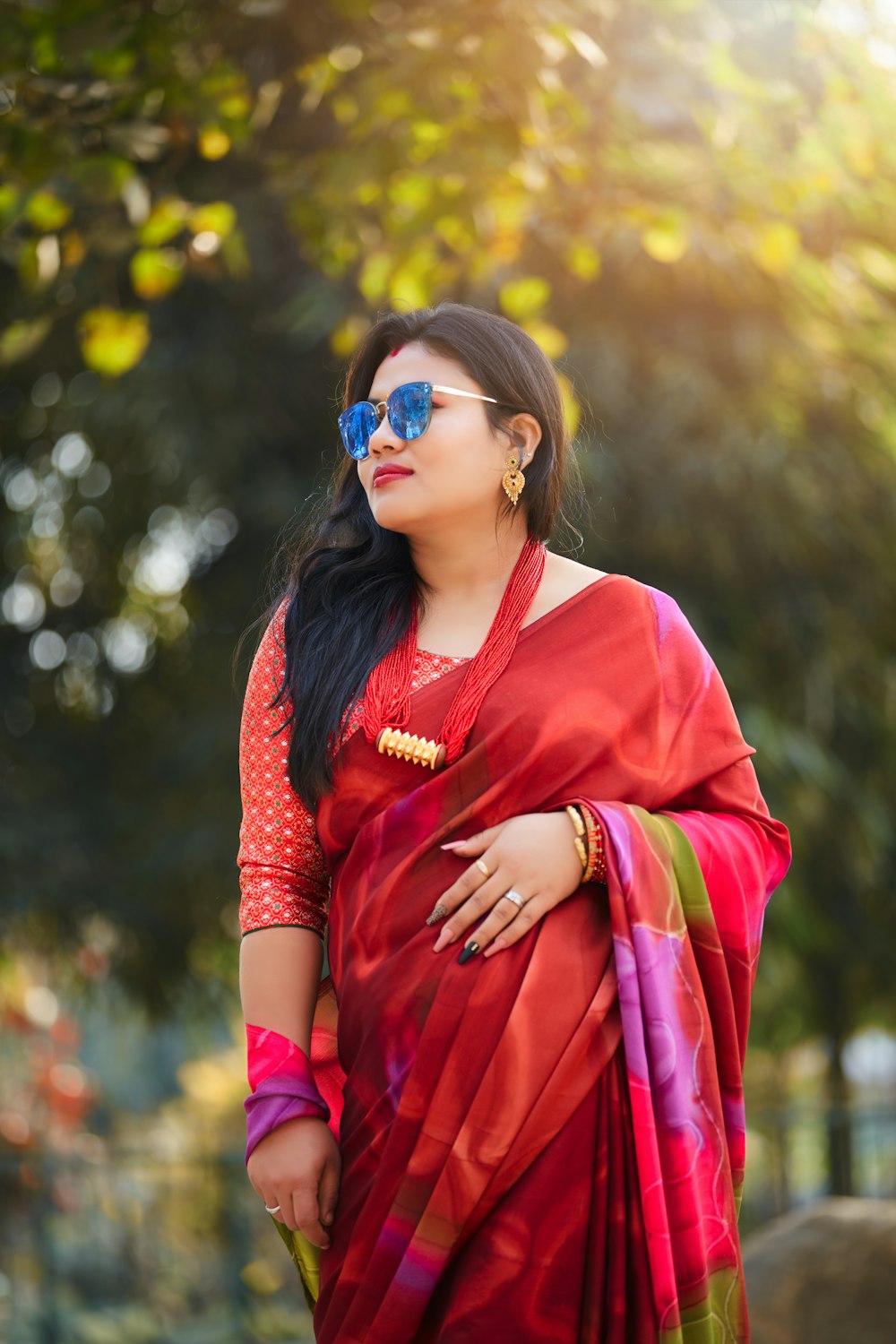 a woman wearing a red sari and sunglasses