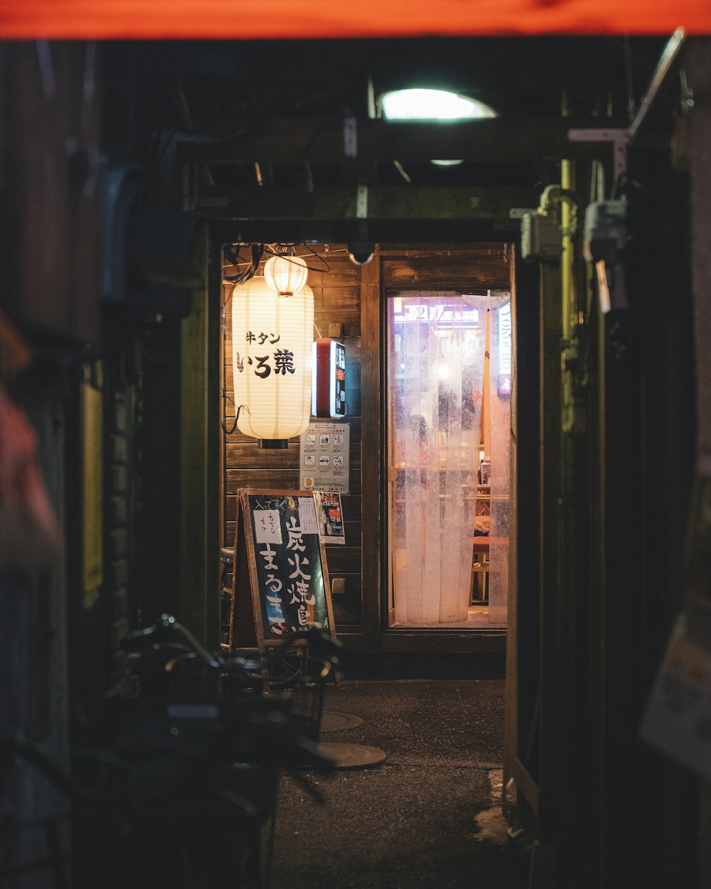 uma porta que leva a um restaurante com uma placa na porta