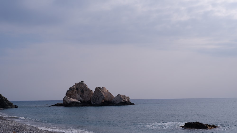 a large rock formation in the middle of a body of water