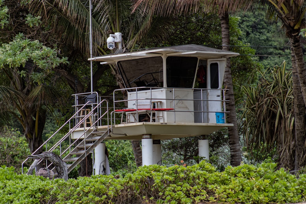 a lifeguard tower sitting on top of a lush green hillside