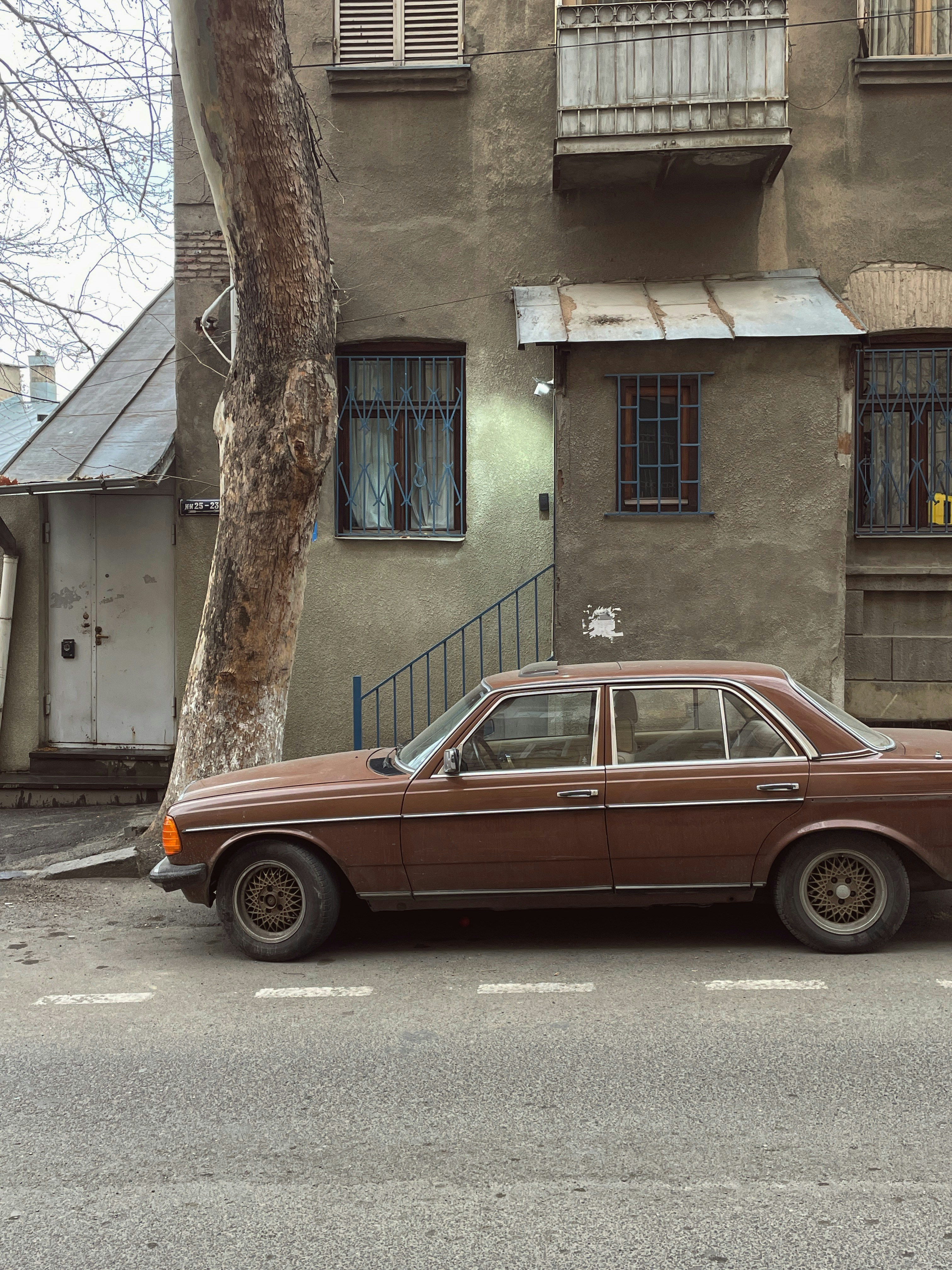 a brown car parked in front of a building
