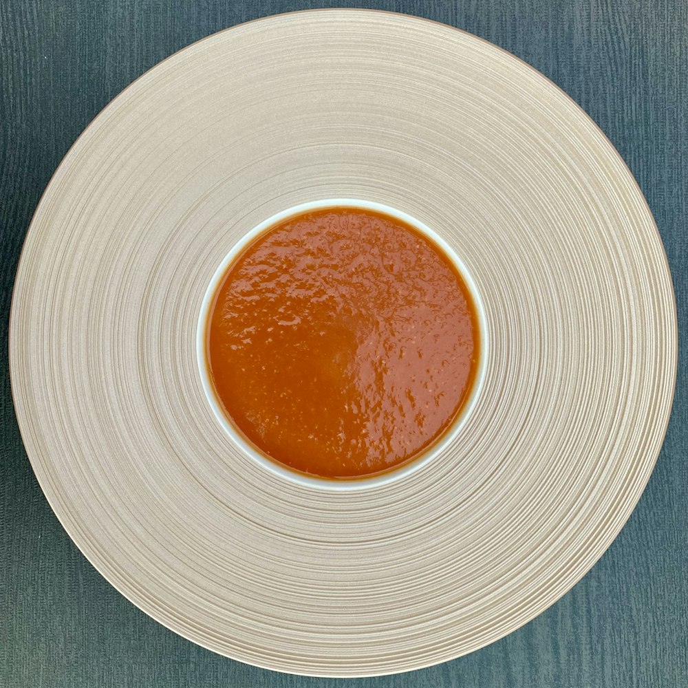 a white plate topped with a sauce on top of a table
