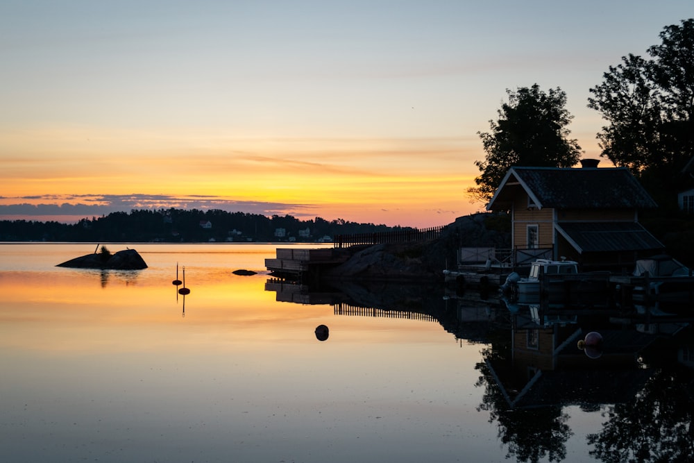 a lake with a house and a boat in the water