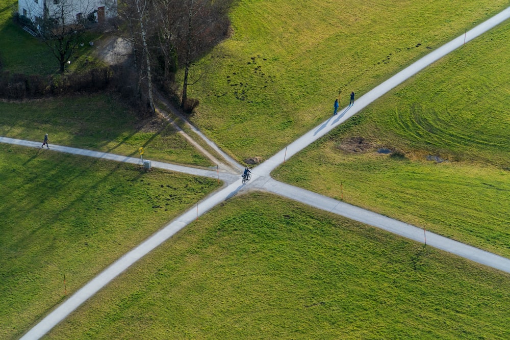 a group of people walking across a grass covered field