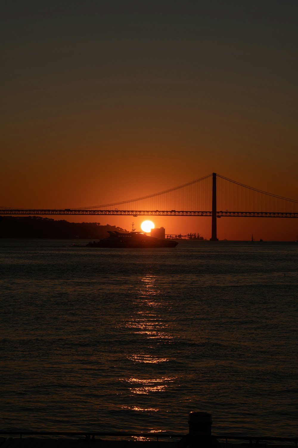 the sun is setting over the bay bridge