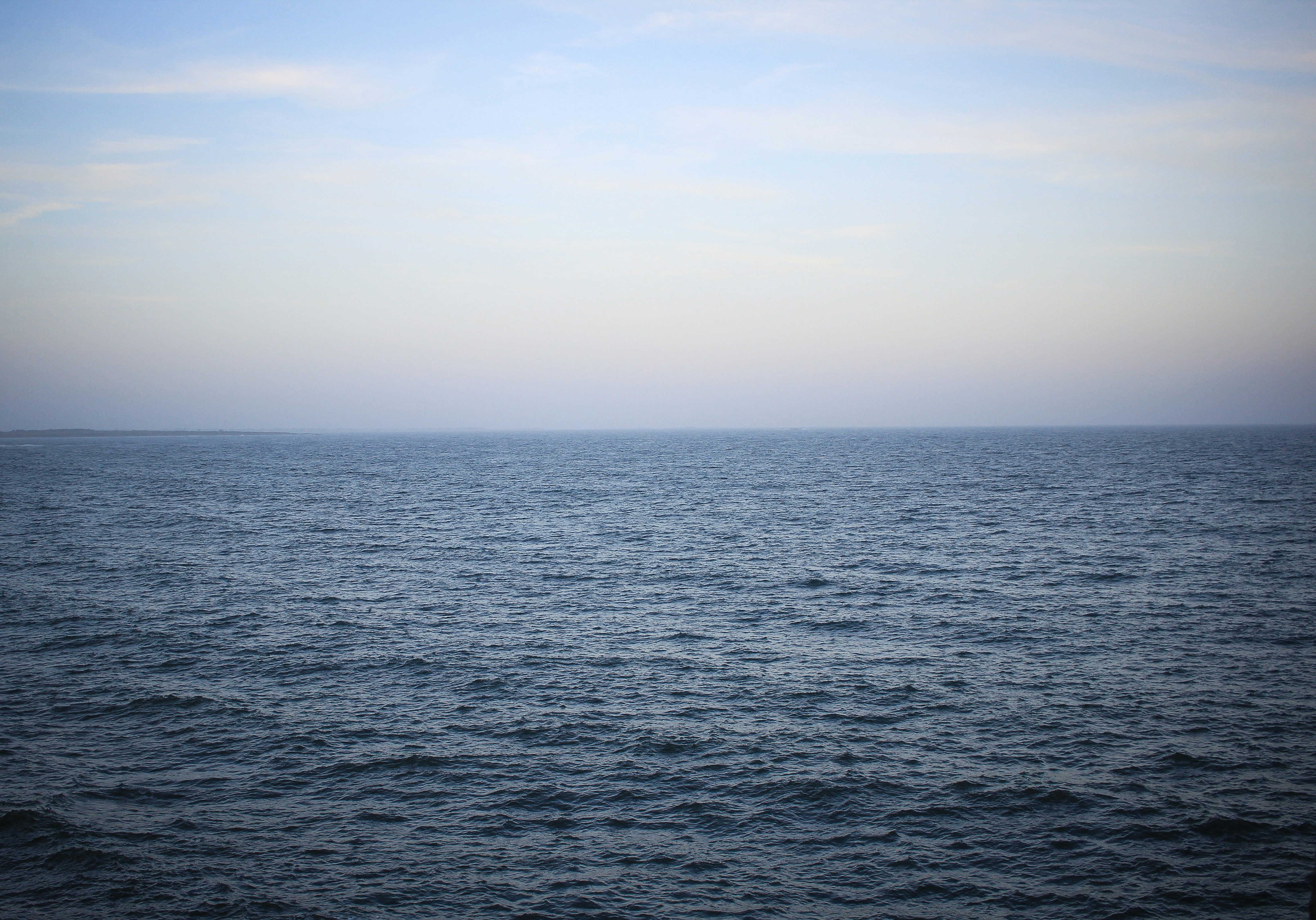 a body of water with a sky in the background