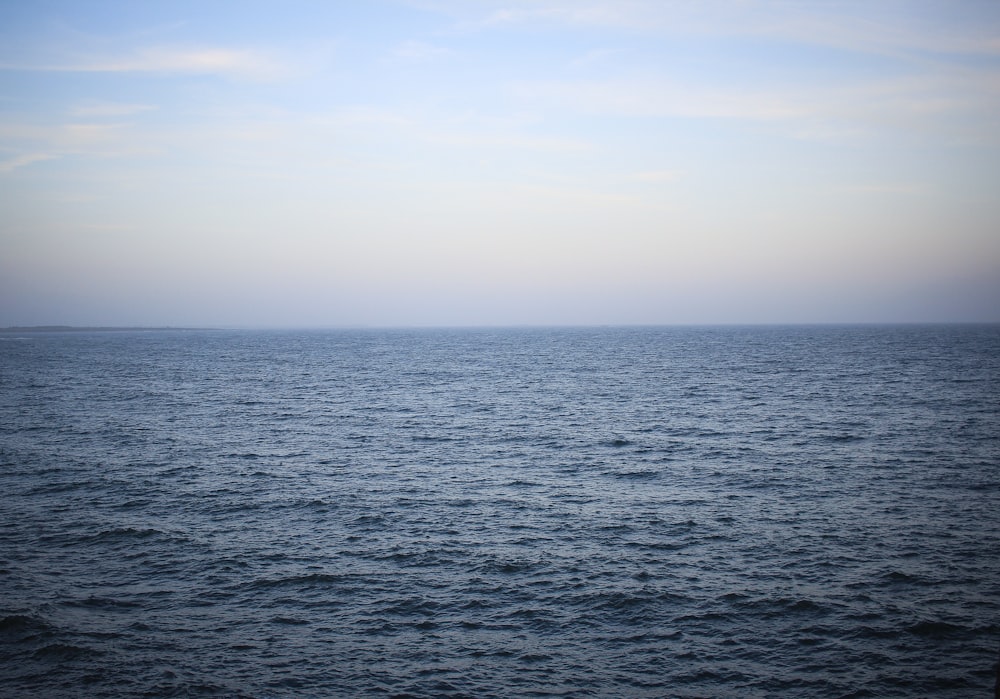 a body of water with a sky in the background