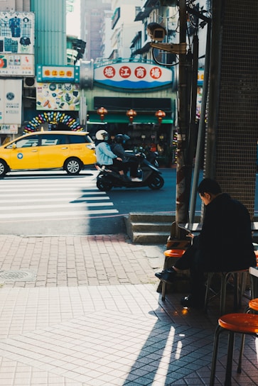 A vibrant city street scene showing a Big Giant Rides motorcycle taxi weaving through traffic with a happy passenger.