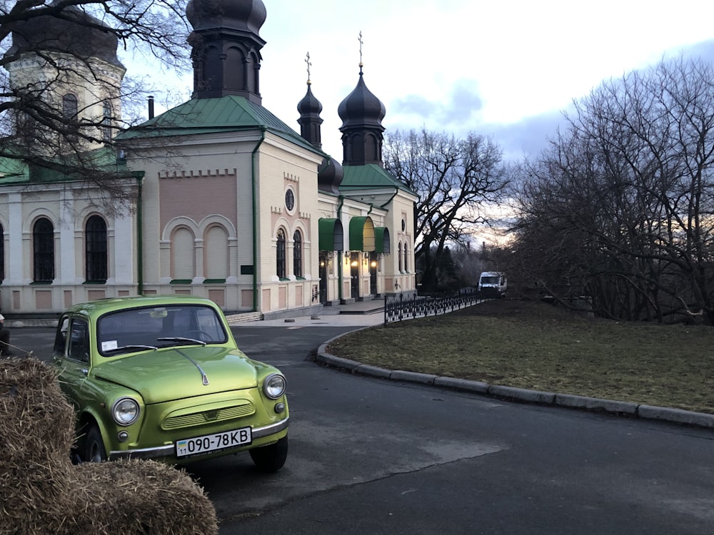 a green car parked in front of a building