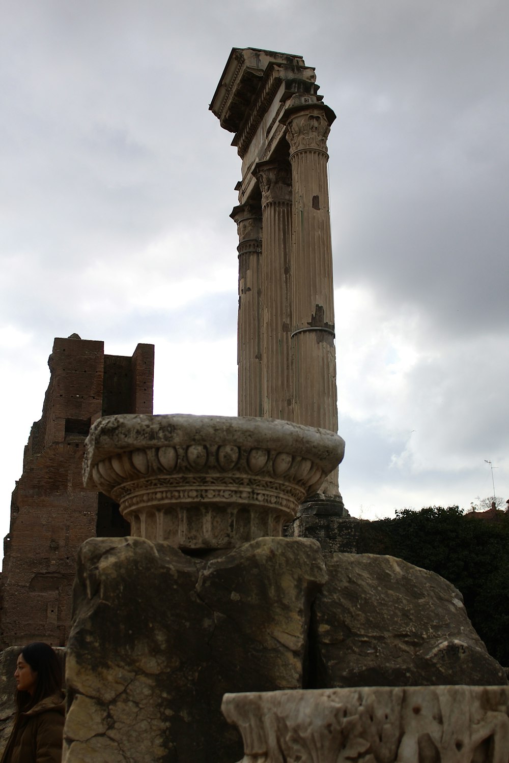 a tall stone pillar sitting next to a tall building