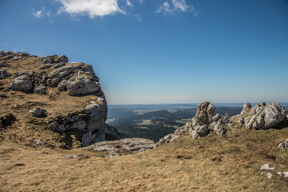 a rocky outcropping with a view of a valley below