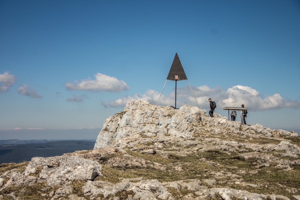 two people standing on top of a rocky hill