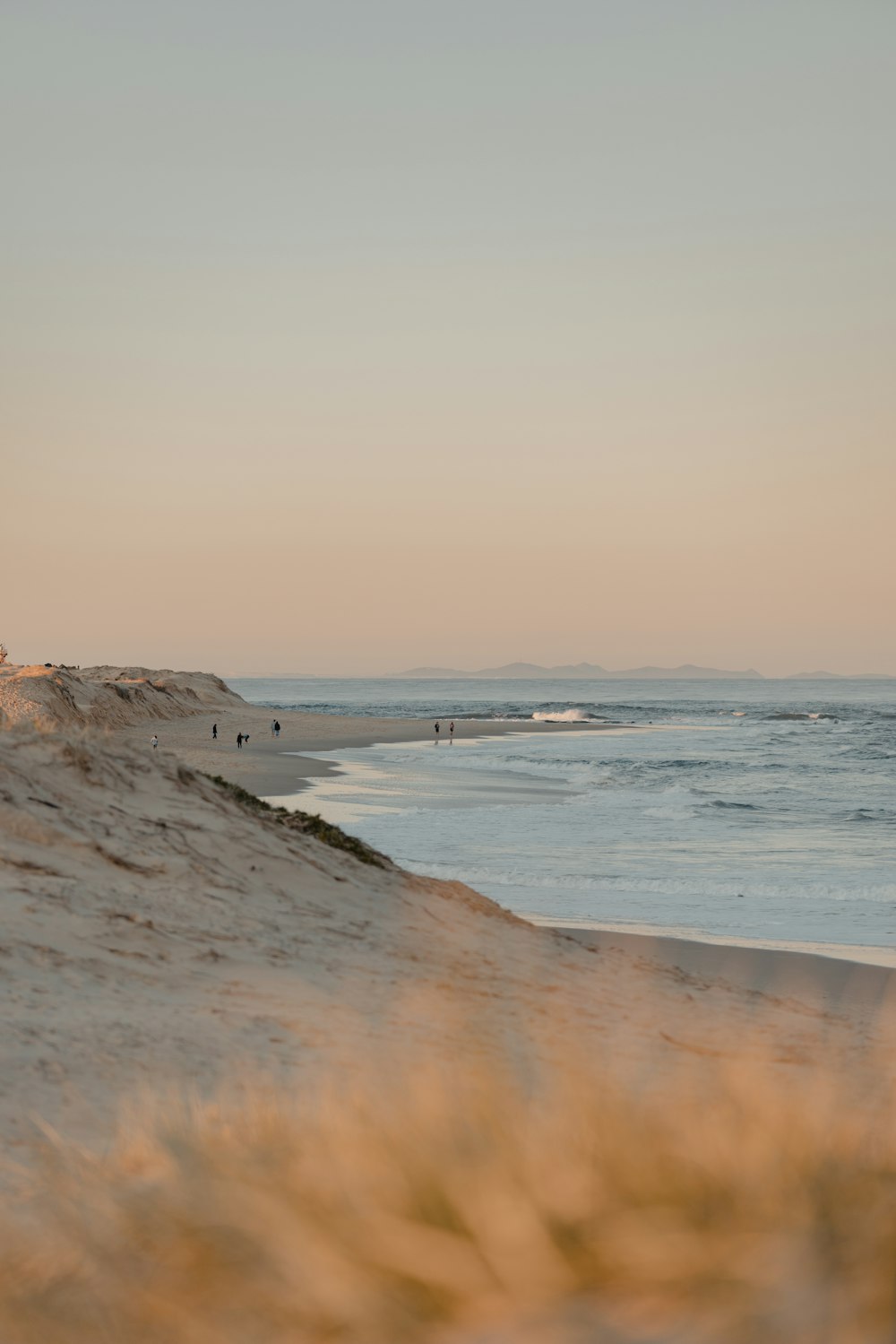 a group of people standing on top of a sandy beach