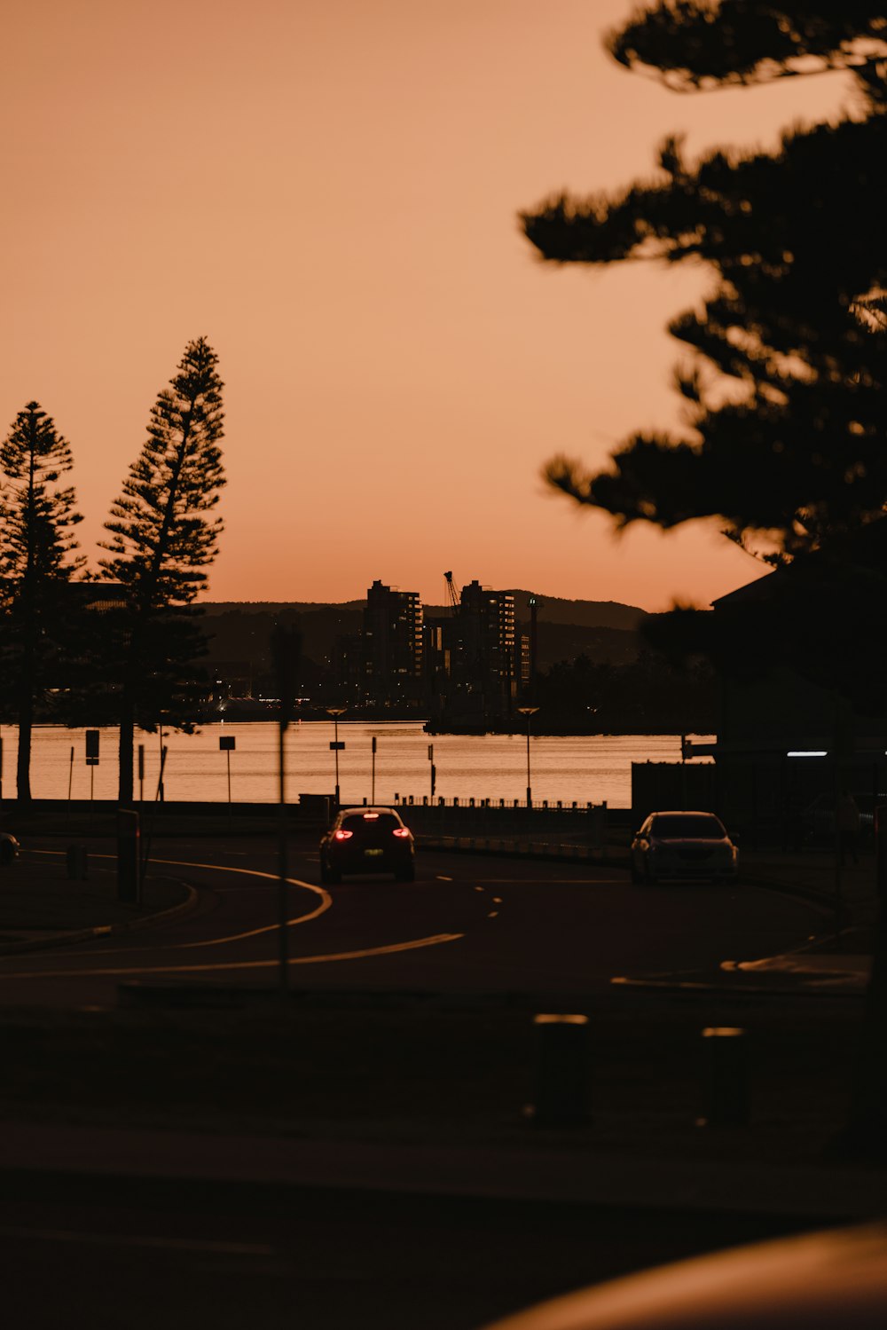 a car driving down a road next to a body of water