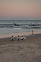 Group of surfers sharing stories and laughs by the shore.
