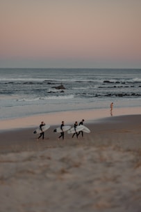 Group of surfers sharing stories and laughs by the shore.