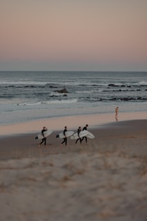 A group of surfers laughing and sharing stories near the shoreline.