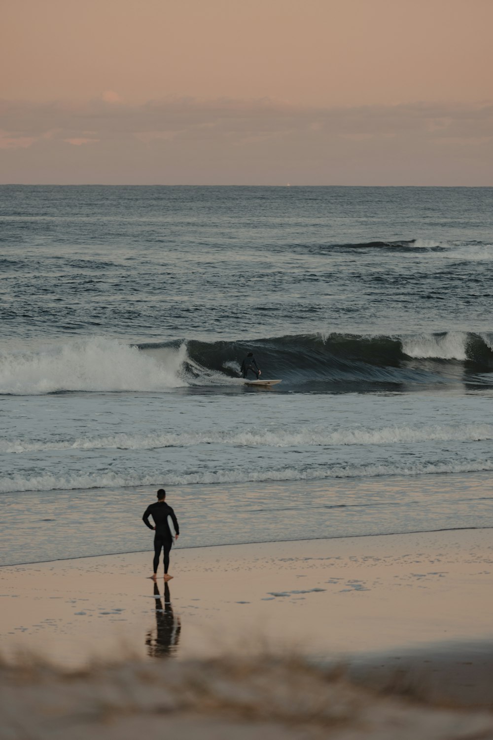 a person standing on a beach next to the ocean