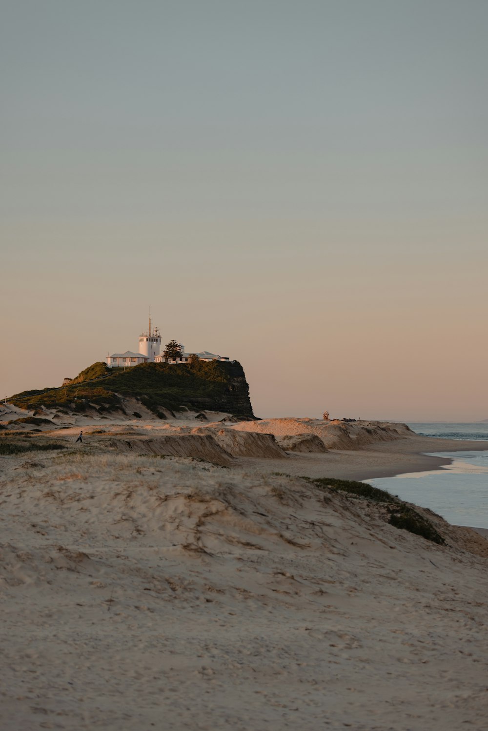 a lighthouse on a small island in the middle of the ocean