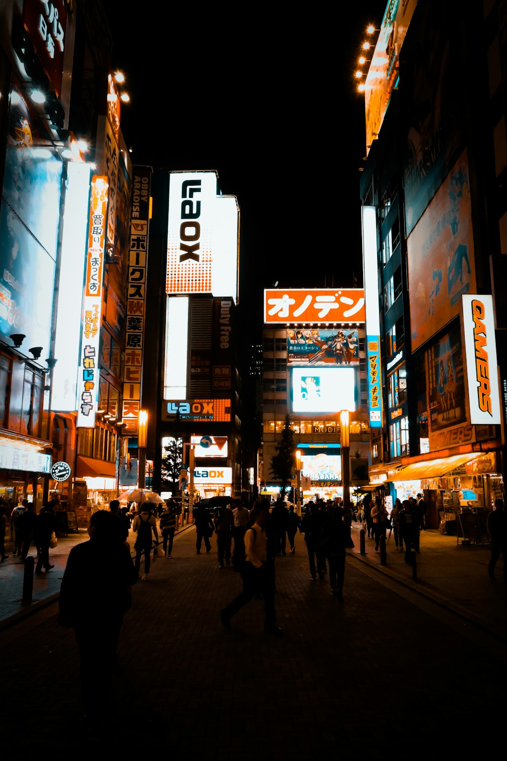 a group of people walking down a street at night