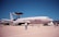 A military aircraft displayed on a runway, marked with 'U.S. AIR FORCE' on its fuselage. It has a large rotating radar dome on top and is surrounded by several people observing or walking by. The sky is clear and blue, and there are no clouds visible.