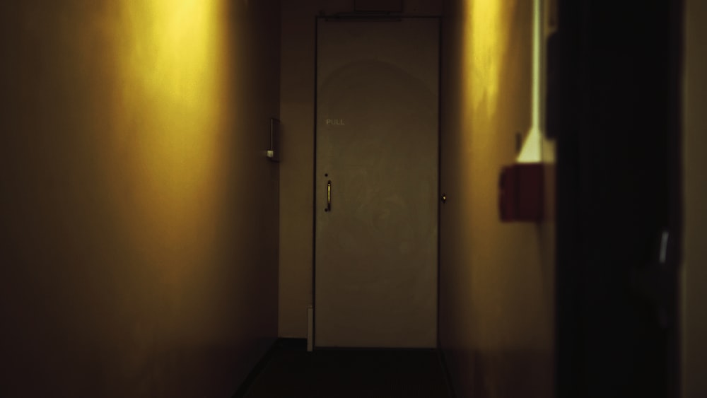 a hallway with a door and a light on the wall