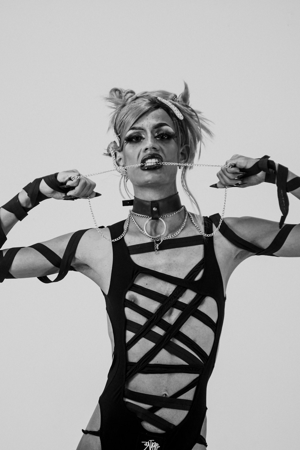 a woman in a caged bodysuit with her hands on her hips