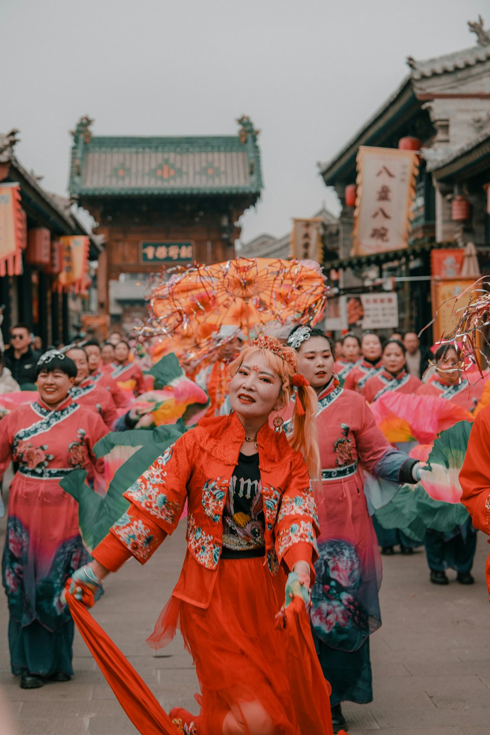 a woman in a red dress dancing in a parade