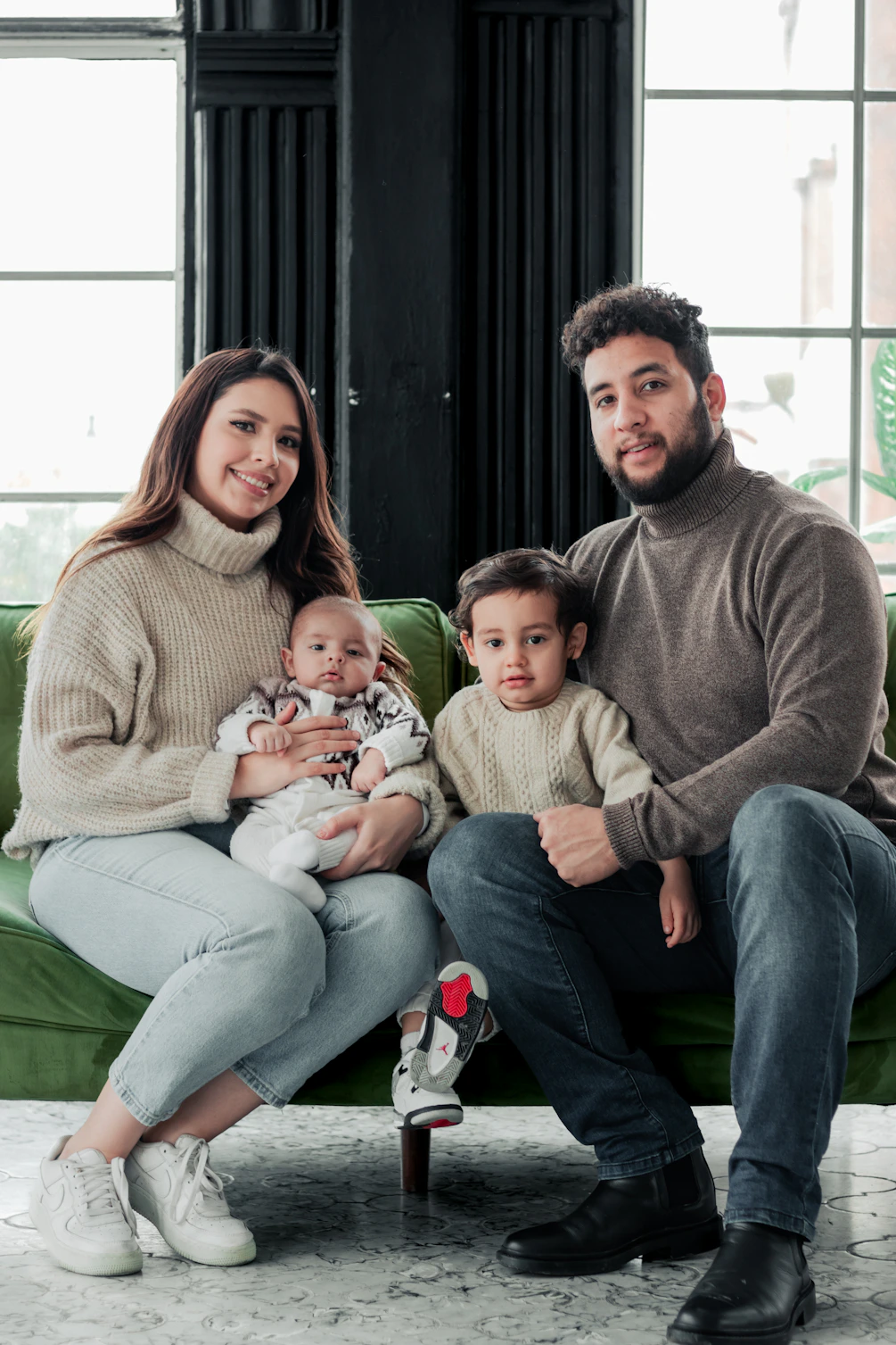 a man and woman sitting on a couch with two children