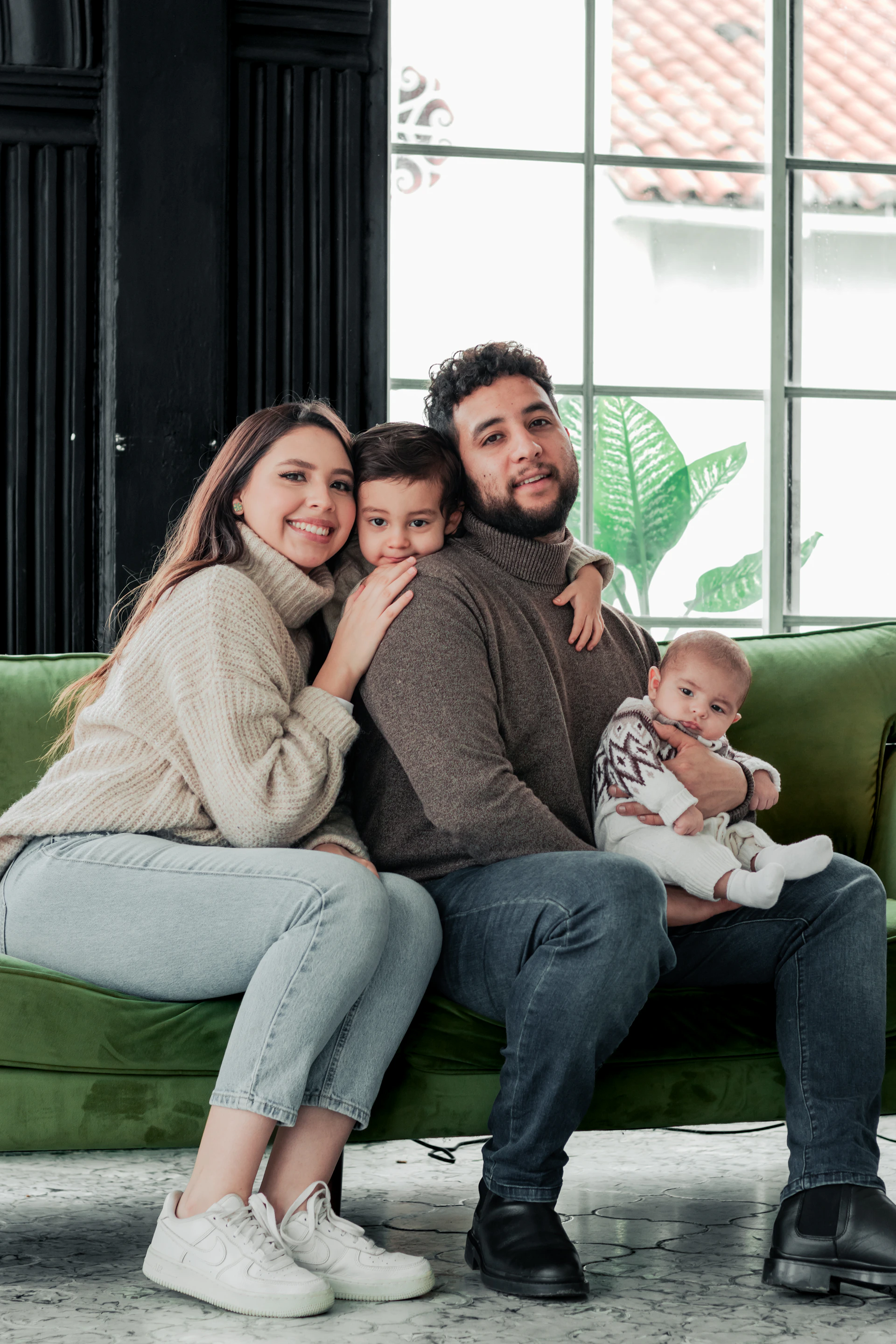 a man and woman sitting on a couch with a baby