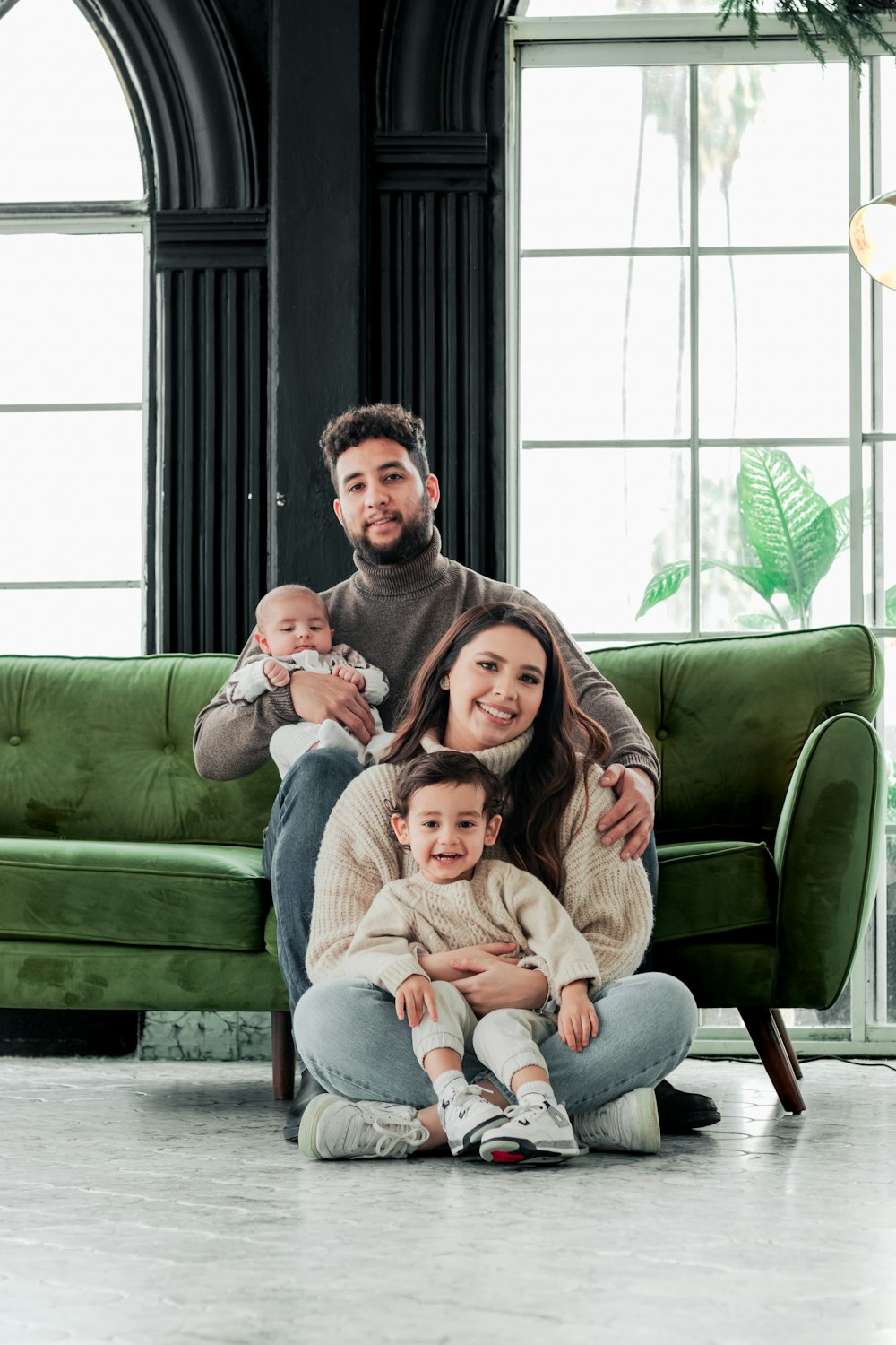 a family sitting on the floor in front of a green couch